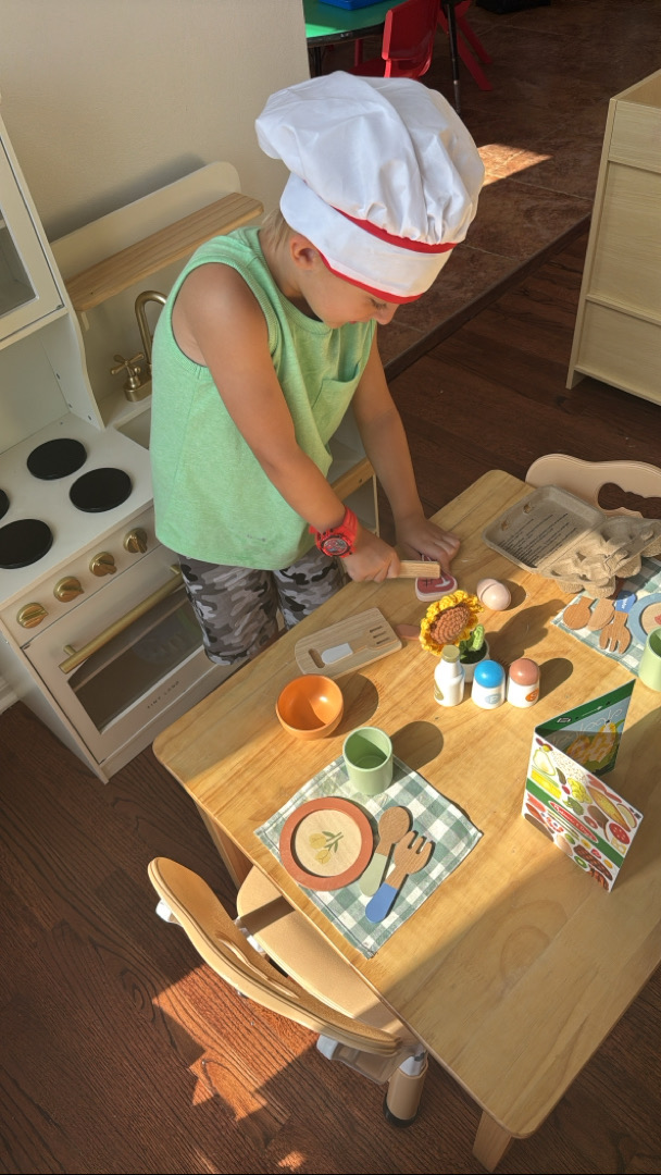 Child playing in toy kitchen