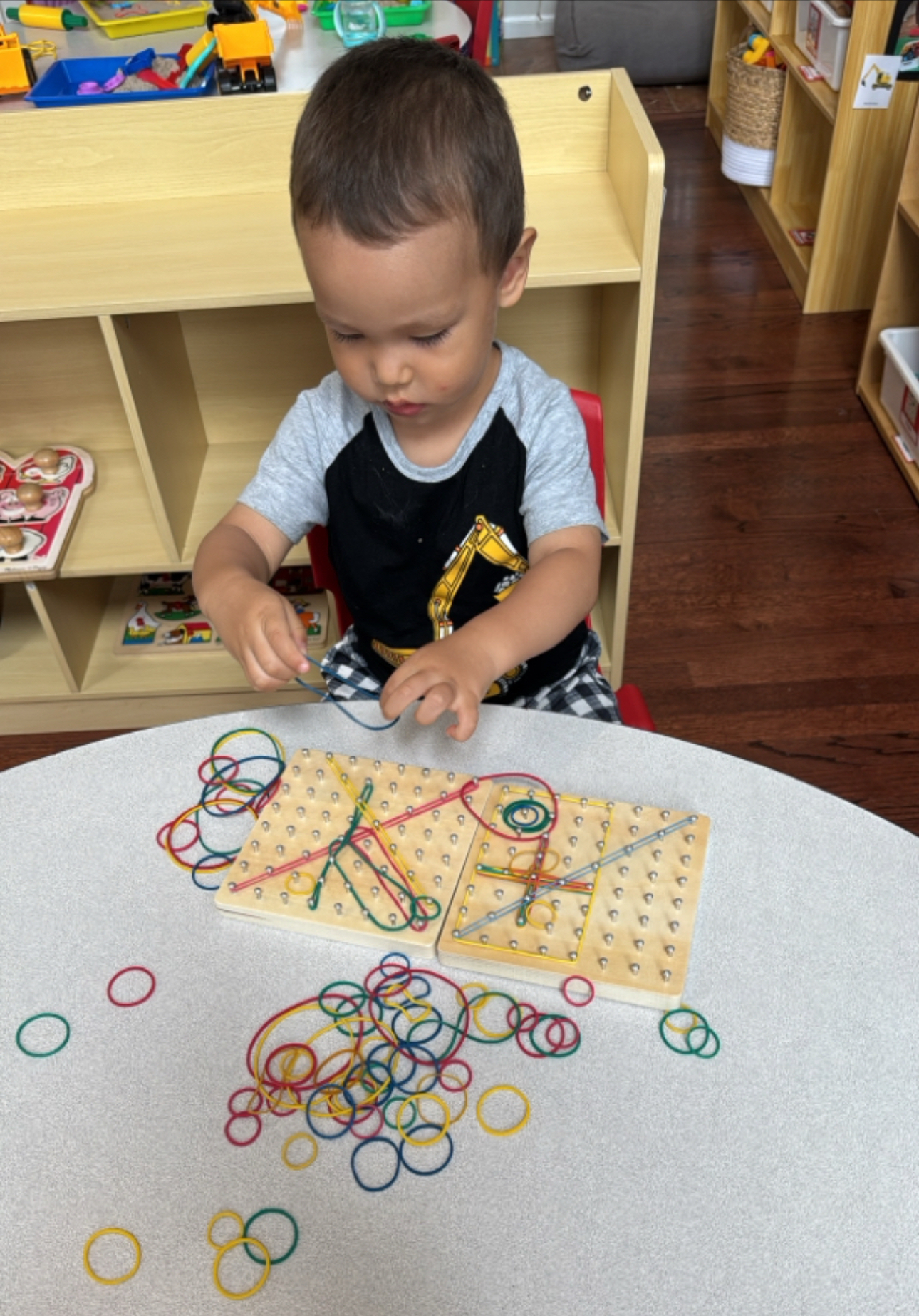 Children playing with markers on carboard with alphabet displayed